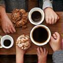 People gathered around a coffee table, smiling.